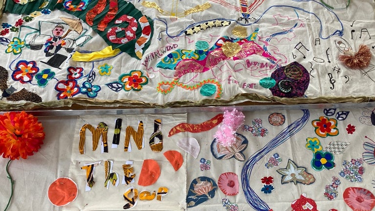 Two large pieces of fabric decorated with brightly coloured pieces of fabric and pens